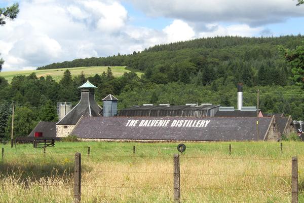 The Balvenie Distillery warehouses and pagoda roofs beside fields near Dufftown