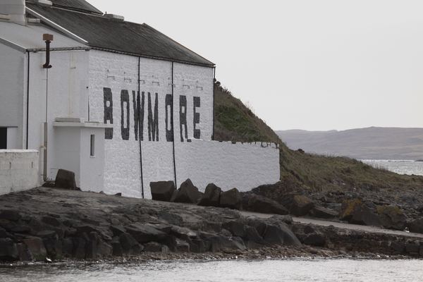 Bowmore Distillery's whitewashed sea wall with the name painted in black, Islay