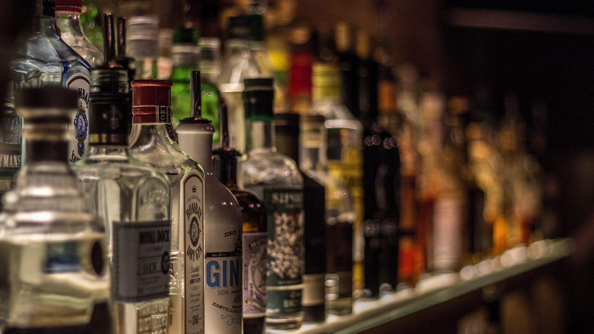 Warmly lit back bar shelves of bottles for our best whisky Malaysia guide