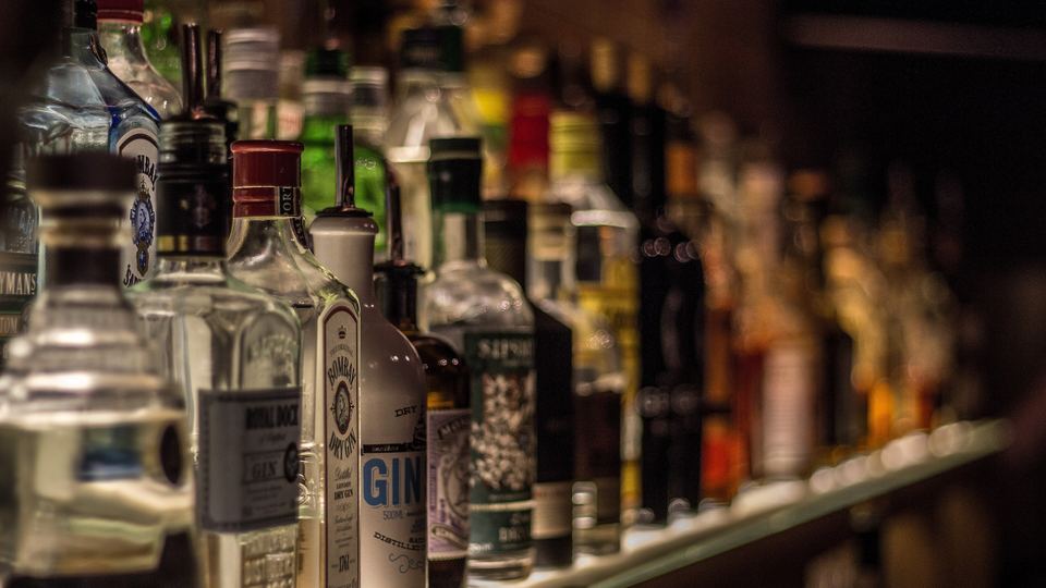 Back bar shelves lined with spirit bottles under warm light