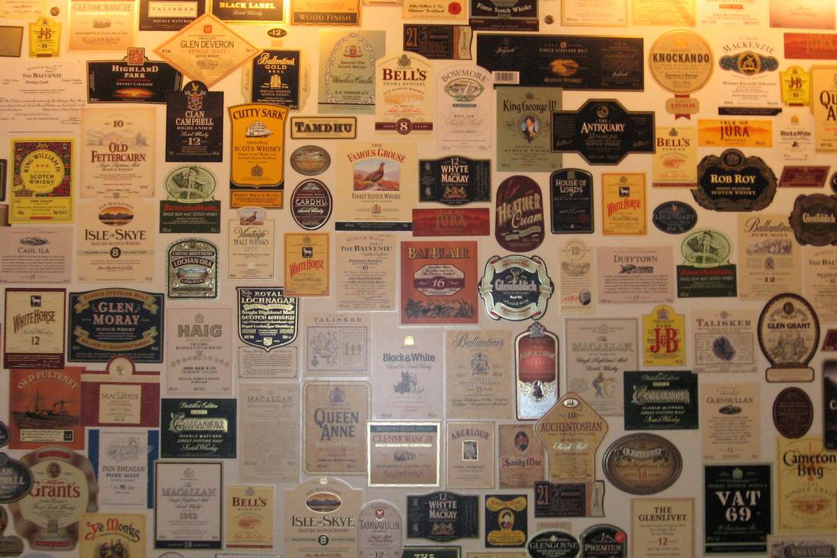 Wall of vintage labels from many brands of blended Scotch whisky